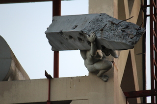 An art installation in Nicosia with a woman carrying a heavy pillar